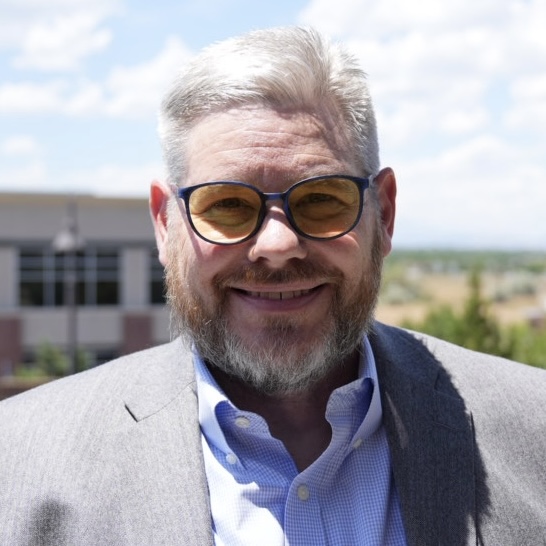 Don Davis in front of a building and clouds