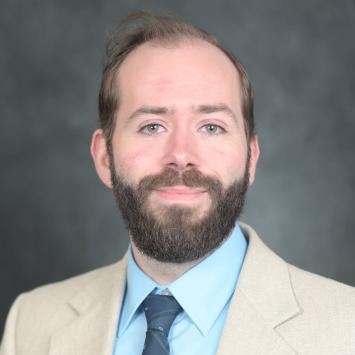 Alexis Ducote headshot in a suit
