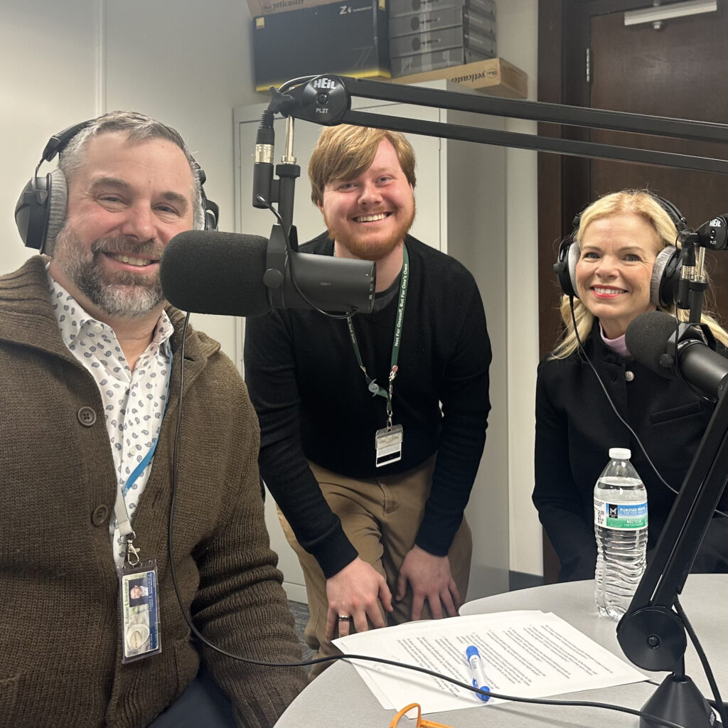 James Zanewicz, Ian McLachlan, and Kimberly Gramm at a table with microphones and headphones