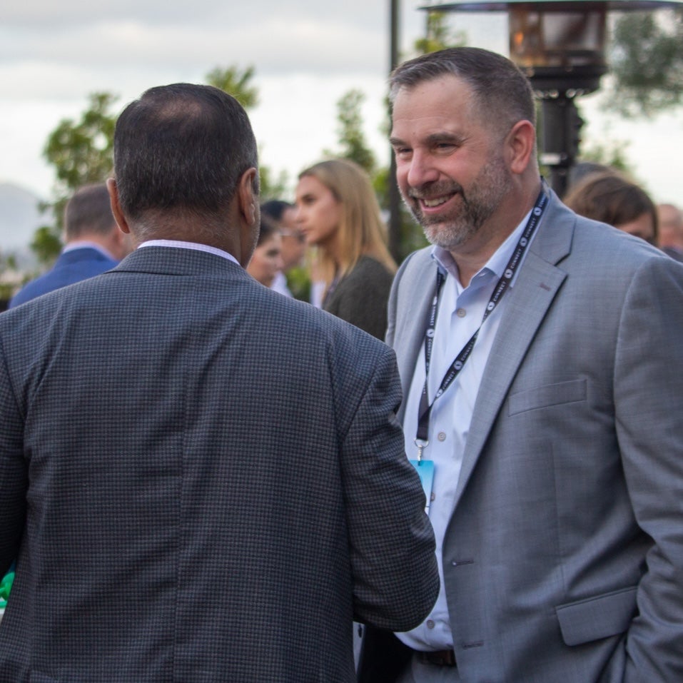 James Zanewicz speaking to a colleague at an outdoor event