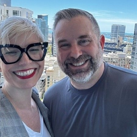 Elaine Hamm and James Zanewicz in front of a city skyline